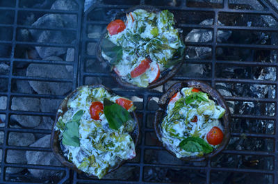 Grilling stuffed portobello mushrooms outdoors on hibachi grill