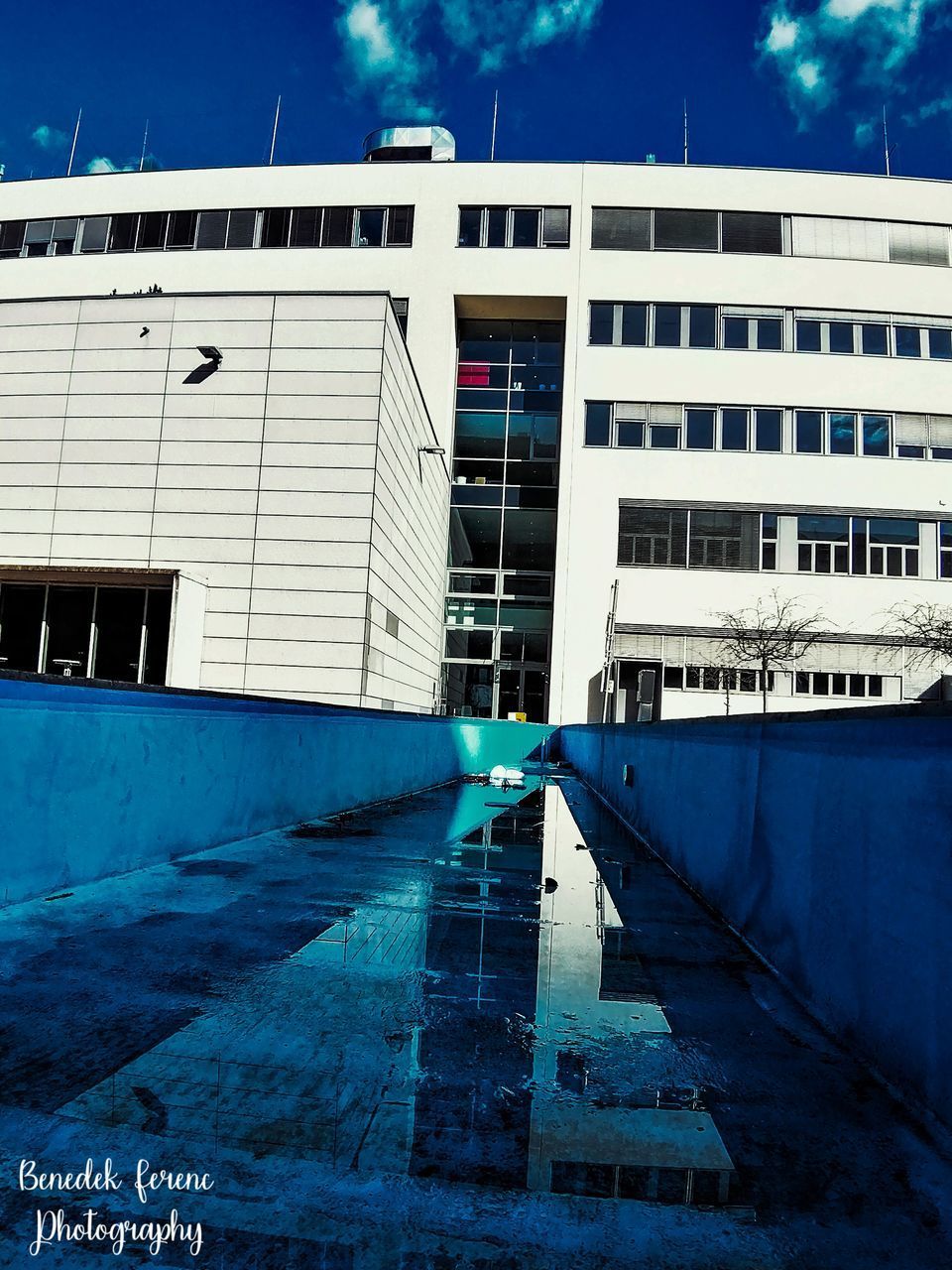 LOW ANGLE VIEW OF SWIMMING POOL AGAINST BUILDINGS