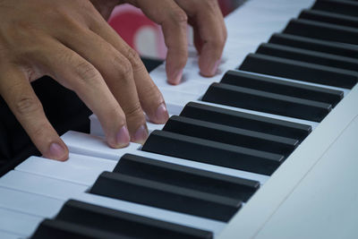 Midsection of person playing piano