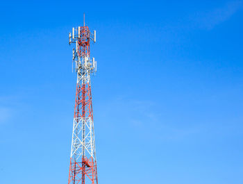 Low angle view of communications tower against blue sky