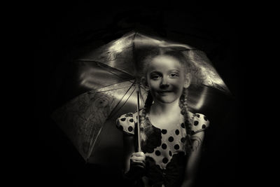 Portrait of a girl wearing mask against black background