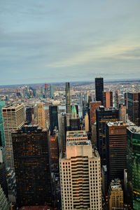 Aerial view of buildings in city against sky