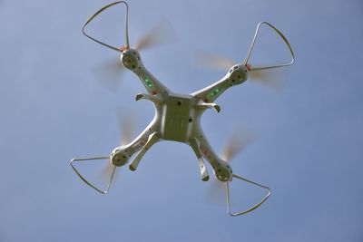 Low angle view of drone against the blue sky