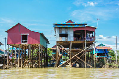 Houses by sea against sky