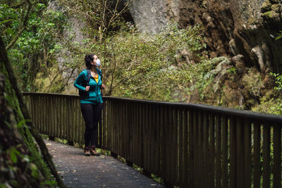 Full length of woman standing on footbridge