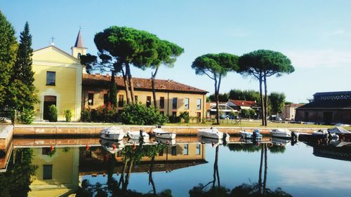 Houses by lake against sky