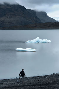 Scenic view of lake by mountains against sky