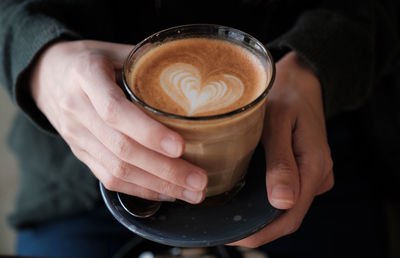 Cropped image of hand holding coffee cup