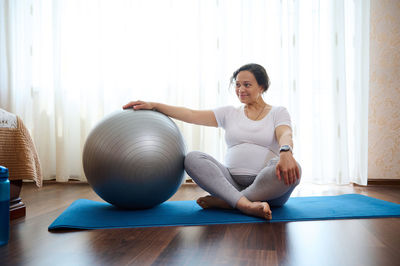 Side view of woman exercising in gym