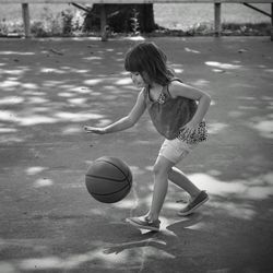 Girl playing with ball on road