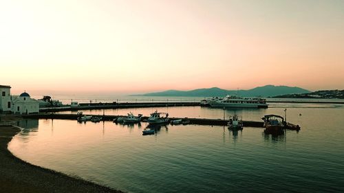 Boats in sea at sunset