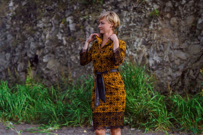 Woman standing against rock formations at beach