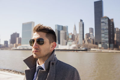 Portrait of a young businessman on a rooftop overlooking the city