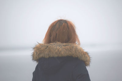 Woman in warm clothing at beach during winter