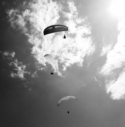 Low angle view of person paragliding against sky