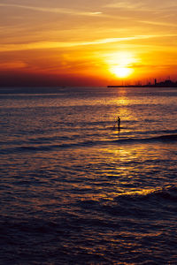 Cascais, portugal sunset with man on standup paddle