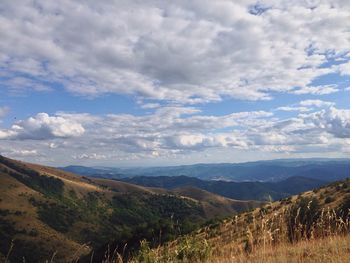 Scenic view of mountains against cloudy sky