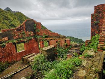 Scenic view of sea by buildings against sky