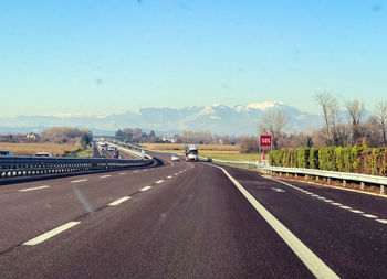 Road leading towards highway against sky in city