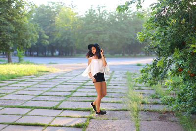 Full length of woman standing against plants