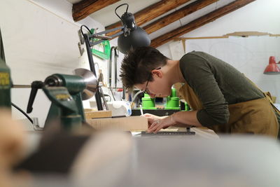 Side view of woman working at table