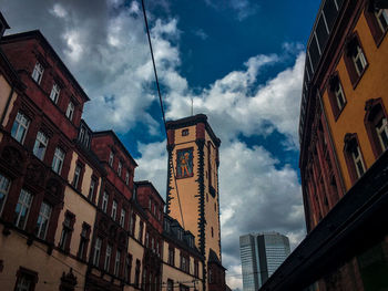 Low angle view of buildings against cloudy sky