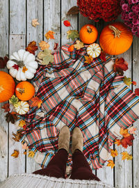 Low section of person standing by pumpkins