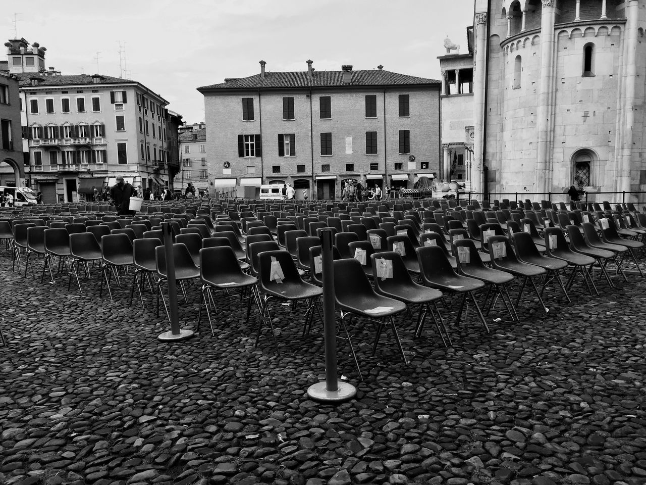 building exterior, architecture, built structure, cobblestone, street, city, in a row, day, outdoors, building, residential building, city life, incidental people, abundance, large group of objects, sky, repetition, transportation, residential structure, no people