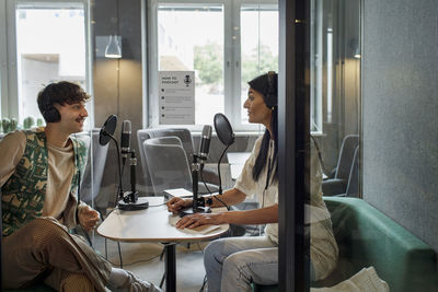 Man and woman doing podcast in studio