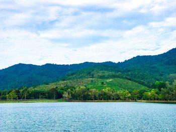 Scenic view of lake by mountains against sky