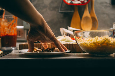 Closeup hand of chef baker in white uniform making pizza at kitchen