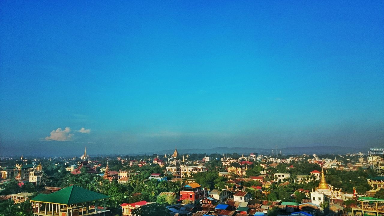 building exterior, cityscape, architecture, built structure, city, crowded, blue, copy space, high angle view, residential district, residential structure, clear sky, aerial view, residential building, sky, town, townscape, outdoors, city life, no people