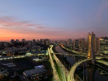 High angle view of illuminated cityscape against sky during sunset