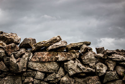 Low angle view of dry stone wall against sky