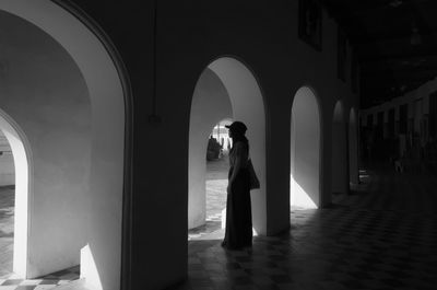Side view of woman standing in corridor