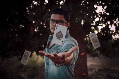 Portrait of young man holding paper outdoors