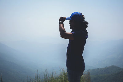 Man looking at mountain against sky