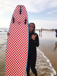 Full length of woman standing at beach against sky