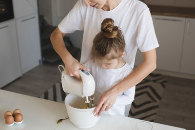 Midsection of mother and daughter preparing food