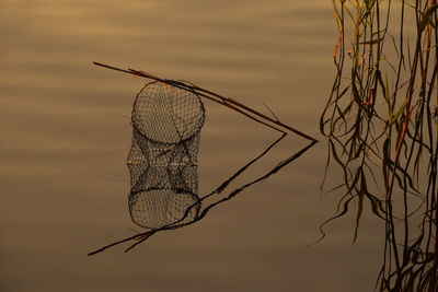 Fishing net in lake during sunset