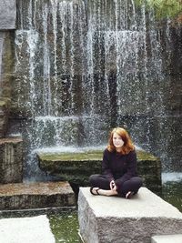 Portrait of woman sitting by lake