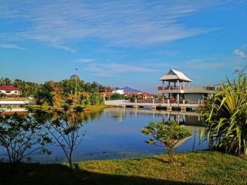 Built structure by lake against blue sky