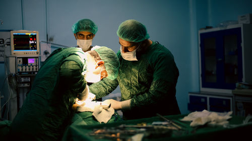 Medical team of surgeons in hospital doing minimal invasive surgical interventions. 