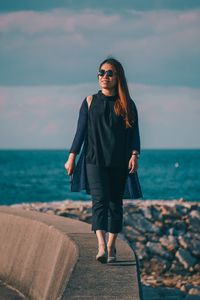 Full length of young woman standing on beach