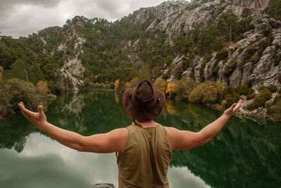 Rear view of a man overlooking lake