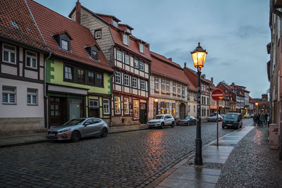 Cars on street amidst buildings against sky