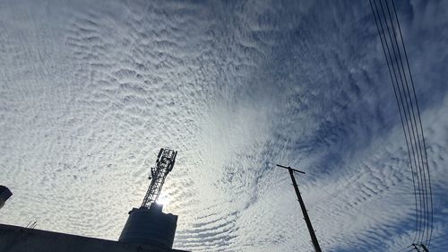 Low angle view of communications tower against sky during winter