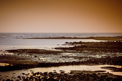 Scenic view of sea against clear sky during sunset