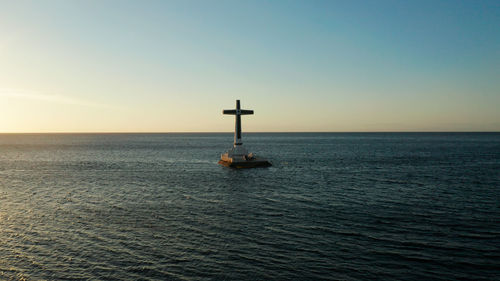 Catholic cross in sunken cemetery in the sea at sunset. sunset at sunken cemetery camiguin island 