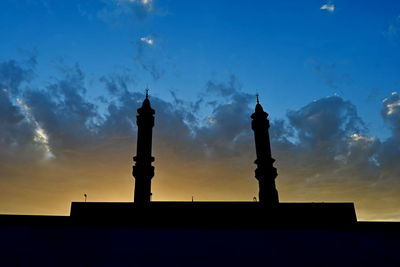 Silhouette of building against cloudy sky